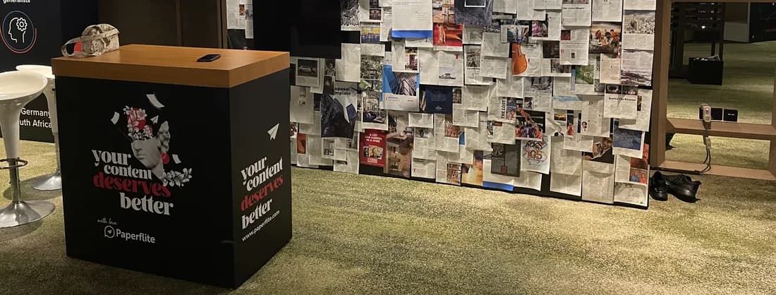 The booth's stall before a wall of pinned pages