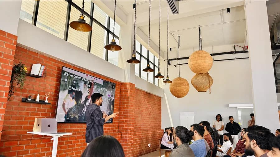 The team gathered under the pendant lamps by the brick wall