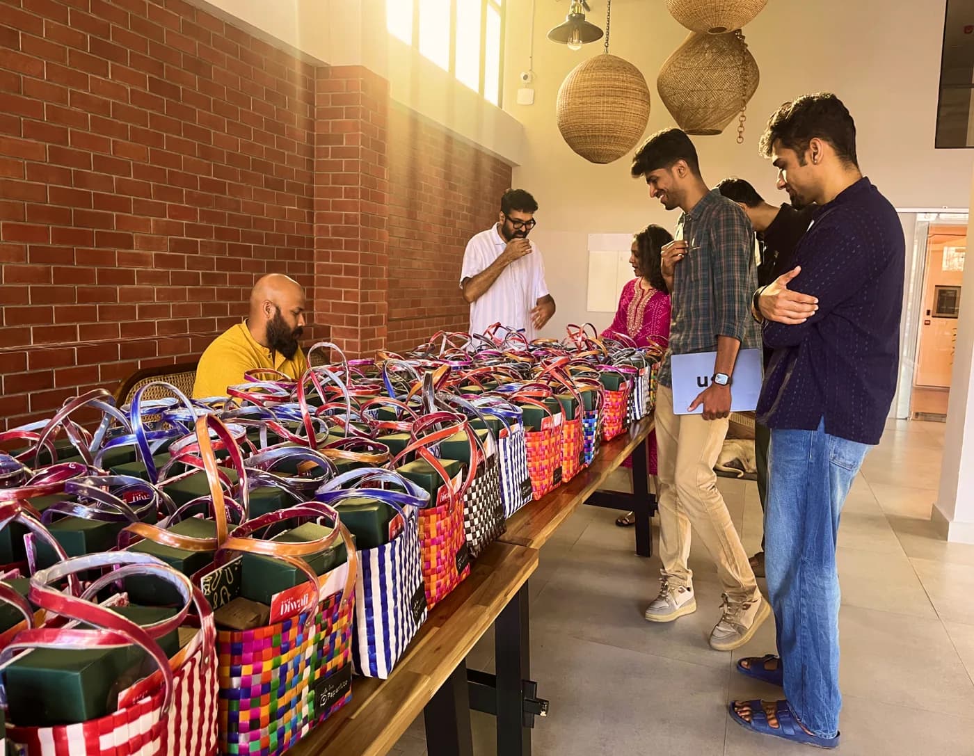 The team at a long table of woven bags, the onboarding kits being packed