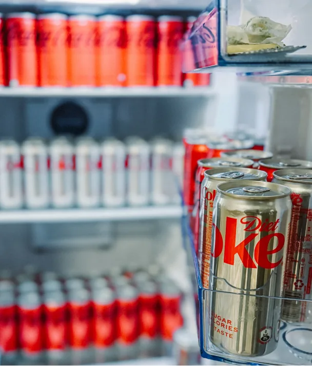 A fridge packed with Coke cans, a gold Diet Coke can in front